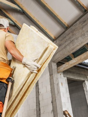 Construction Worker Installing Insulation in Residential Building Under Renovation